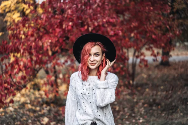 Красива дівчина з рудим волоссям і капелюхом, що йде в парку, осінь — стокове фото