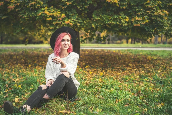 Menina bonita com cabelo vermelho e chapéu relaxante no parque, outono t — Fotografia de Stock