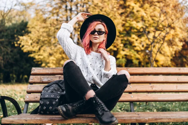 Chica bonita con el pelo rojo y sombrero relajante en el banco en la p — Foto de Stock