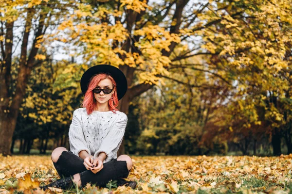 Красива дівчина з рудим волоссям і капелюхом розслабляється в парку, осінь t — стокове фото