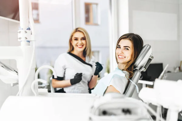 Pretty young female dentist making examination and treatment for — Stock Photo, Image