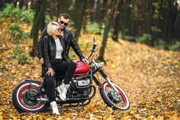 美丽的一对夫妇在红色的摩托车附近的道路上 在森林里 五彩斑斓的背景 关系概念 — 图库照片