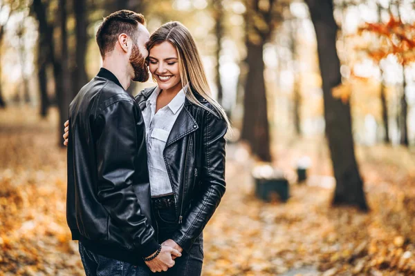 一对年轻夫妇的画像 男人和女人在秋天公园的背景下拥抱和微笑 — 图库照片