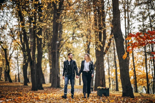 一对快乐的恋人在秋天的公园里散步的肖像 男人和女人牵着手笑着 — 图库照片