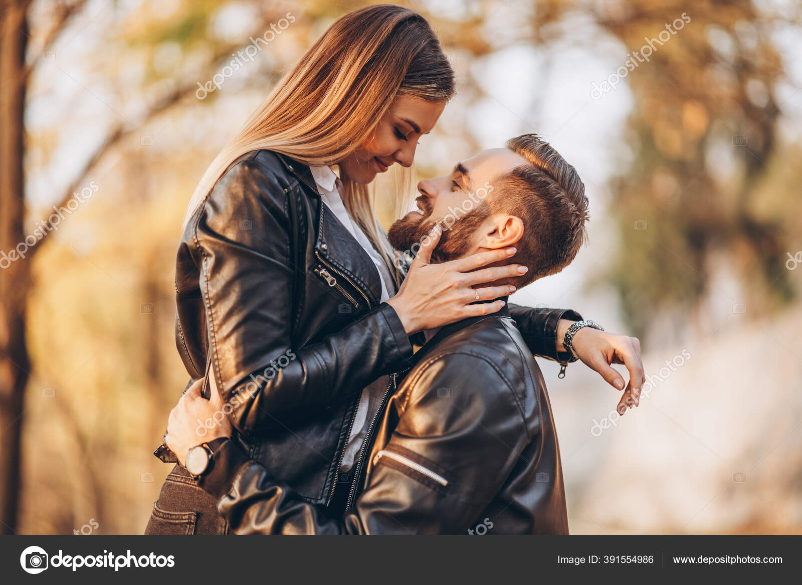 秋の公園を背景にキスをする若いカップル 男が腕の中で女を育てた ストック写真 C Bedya