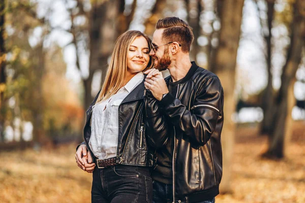 一对恋爱中的年轻夫妇在一个阳光灿烂的日子漫步在秋天的公园里 男人轻轻拥抱着女人 爱情故事 — 图库照片