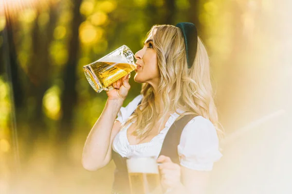 Całkiem Szczęśliwa Blondynka Dirndl Tradycyjnej Sukni Festiwalowej Trzymająca Dwa Kubki — Zdjęcie stockowe