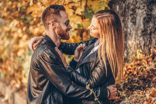 秋の公園を歩く若い愛情のあるカップルの日当たりの良い肖像画 彼らは抱擁と笑顔 散歩を楽しむ — ストック写真