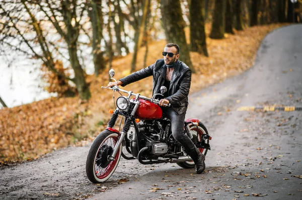 Brutalny Mężczyzna Okularach Przeciwsłonecznych Skórzanej Kurtce Siedzący Motocyklu Drodze Lesie — Zdjęcie stockowe