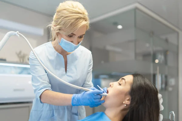 歯科医院の女性歯科医は 女性患者の口腔の検査と治療を提供しています — ストック写真