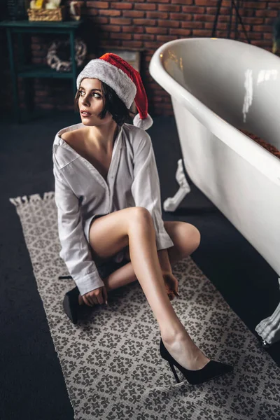 Una Giovane Bruna Posa Sul Pavimento Vicino Bagno Cappello Natale — Foto Stock