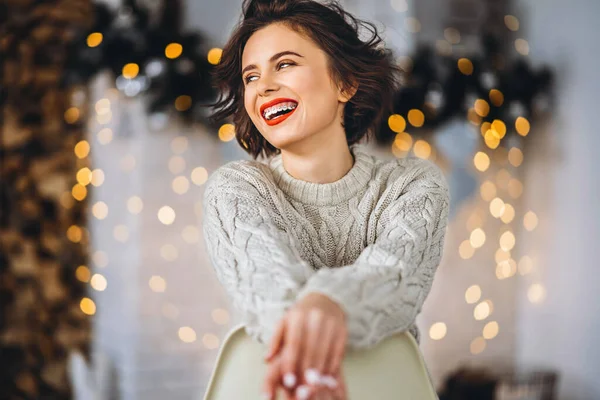 Bonita Feliz Morena Sentada Suéter Caliente Silla Con Luces Navidad — Foto de Stock