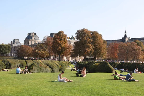 人々はルーブル美術館の前にあるチュイルリー公園の芝生の上で休んでいます パリだ 2011年9月30日 — ストック写真
