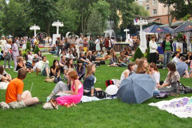 Çimenlikte oturan pek çok gencin. Moskova. 01.08.2009