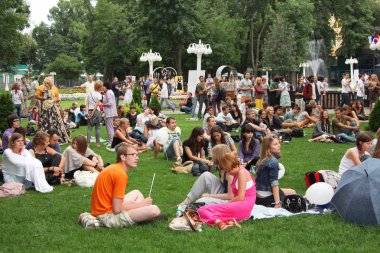 Parkta çimenler üzerinde dinlenme pek çok gencin. Moskova. 01.08.2009