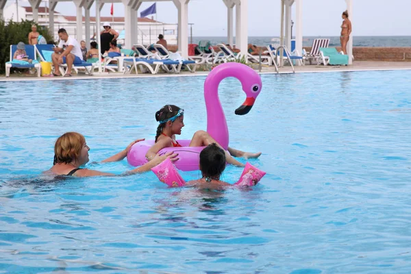 Mulher Com Crianças Praia Nadando Piscina Com Flamingos Infláveis Rosa — Fotografia de Stock