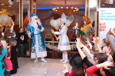 Çocuklar için Noel Baba ve kar kızlık alışveriş merkezi ile yeni yıl performansta havai fişek patlama bekliyor. Moskova. 25.12.2009