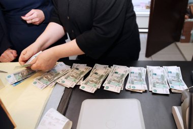 Kasiyer para, banknot bin ruble değer bir paket sayar ve onlara verir. 