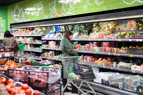 Женщина выбирает помидоры в магазине. В Москве. В 2019 году — стоковое фото