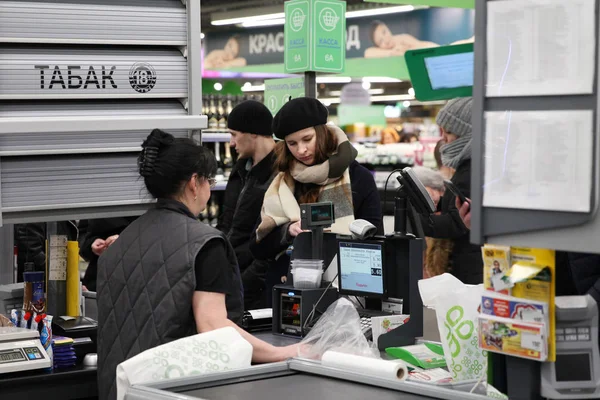 Girl in the beret pays for purchases at the box office of the sh — Stock Photo, Image