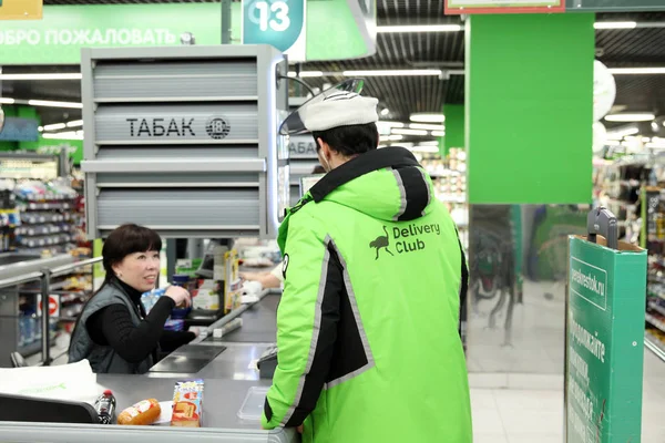 El hombre del servicio de reparto de comida "Delivery-club" paga por purc — Foto de Stock