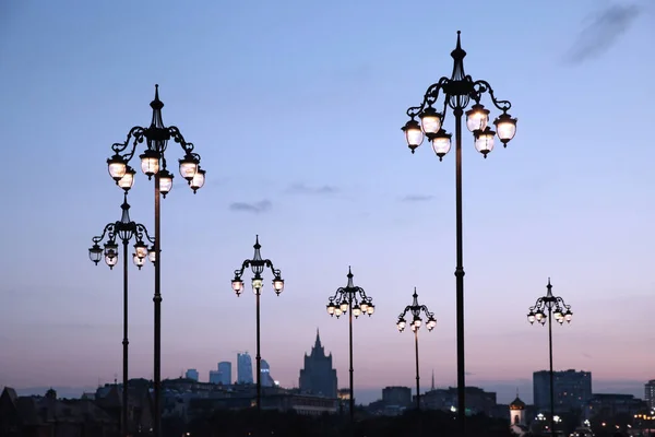 Luces de calle en el puente del Patriarca contra la ciudad nocturna . — Foto de Stock