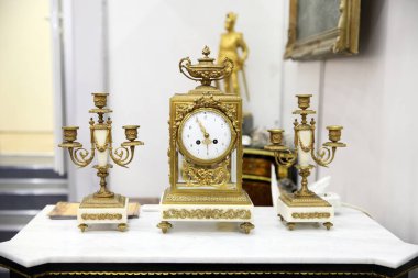 Vintage güzel bir saat ve beyaz masada iki şamdanları