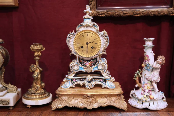 Красивые винтажные часы, подсвечник, фигурка на деревянном столике — стоковое фото