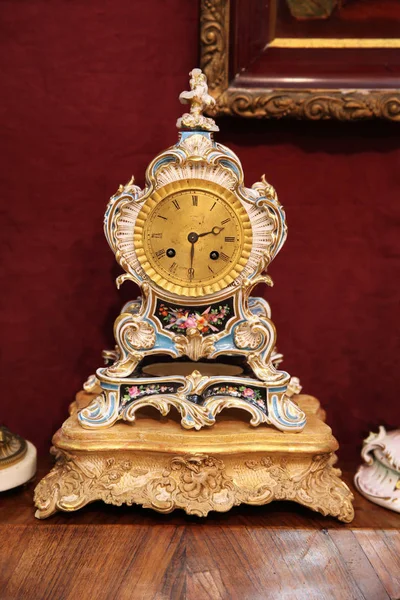 Relógio bonito vintage com guarnição de porcelana em uma mesa de madeira — Fotografia de Stock