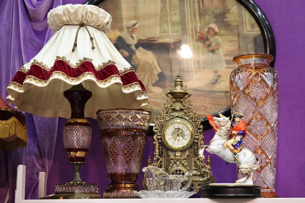 Античная лампа с абажуром, часами и большими стеклянными вазами — стоковое фото