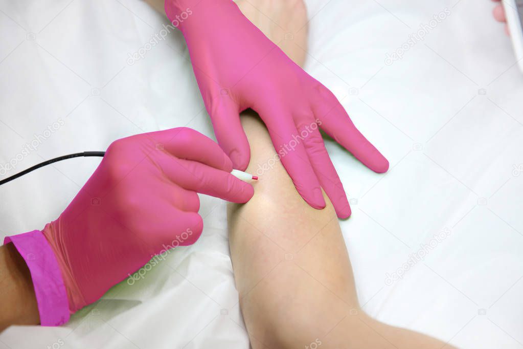 Female hand gloves when removing hair with electric hair removal