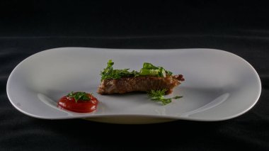 Beyaz bir tabakta taze pişmiş biftek.