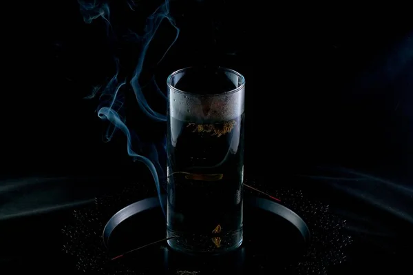 在香烟熏天的背景下 用玻璃瓶中的花朵煮中国茶 — 图库照片