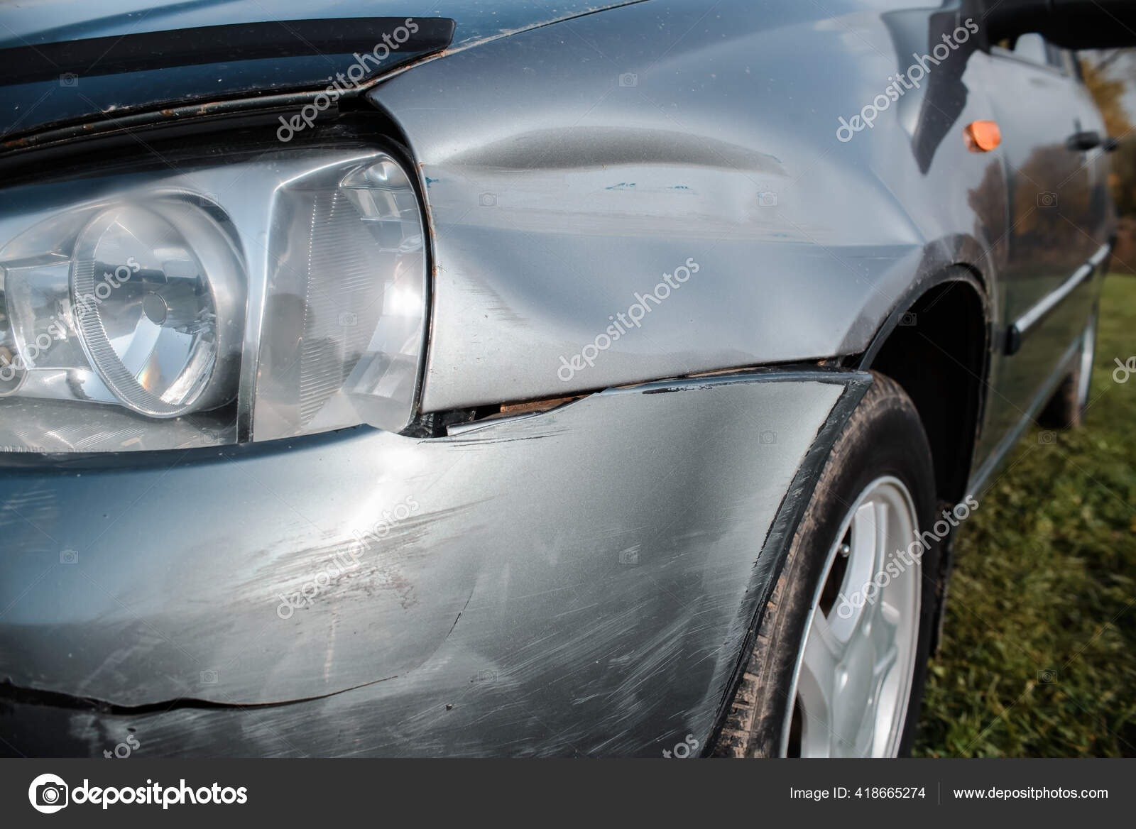 Closeup of side part of auto wheel and fender with cracks, dents and  scratches after road accident, broken vehicle with destroyed auto body.  Outdoor shot. Stock Photo