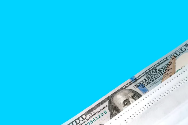 Tıbbi Bir Maskenin Altında Yüz Dolarlık Banknot Mavi Arka Planda — Stok fotoğraf