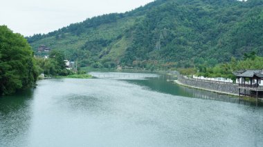 Klasik ahşap köprü manzarası Çin kırsalında yer almaktadır.