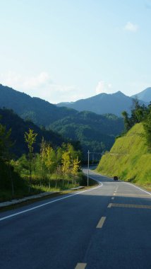 Yeşil ormanlı güzel dağlar ve Çin 'in kırsal kesimindeki bir uçurumun üzerine inşa edilmiş tahta bir yol.