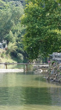 Klasik ahşap köprü manzarası Çin kırsalında yer almaktadır.