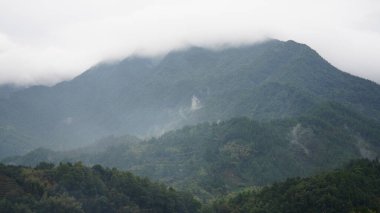 Güzel dağların manzarası, üzerlerinde sis var.
