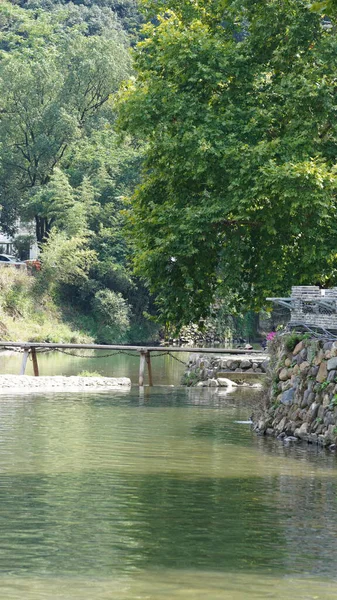 Klasik ahşap köprü manzarası Çin kırsalında yer almaktadır.