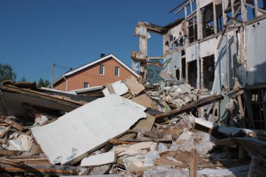 Yeni bir evin arka planında yıkılmış bir ev