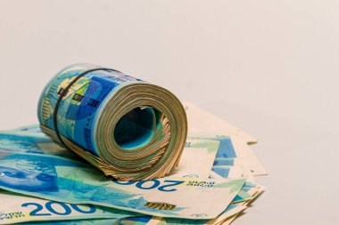 Yeni İsrail şekelinin parasından bahsediyorum. 200 şekel banknot. Banknotlar bir banknotun üzerine yuvarlandı..