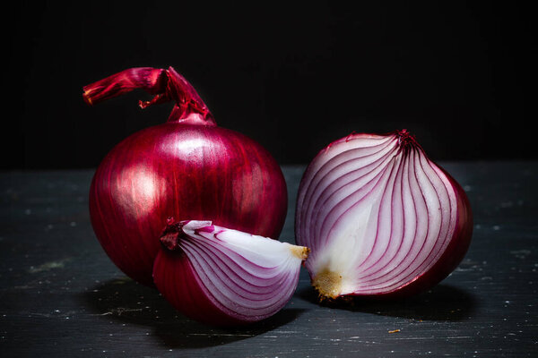 Red onion on a black background. Food photography.