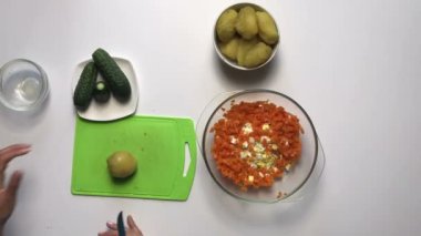 Rus et salatası sebze ve mayonez. Kadın malzemeleri keser ve onları bir kap içinde karışımları