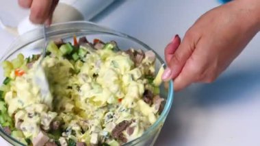 Rus et salatası sebze ve mayonez. Bir kadın mayonez salata için malzemeler ile karışımları.