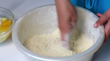 Bir kadın bir mermer kek yapmak için malzemeleri karıştırır. Tablo yanında diğer unsurlarıdır.