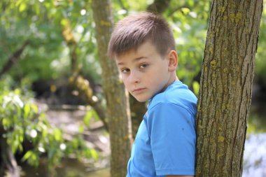 Bir gencin parkta yürürken bir fotoğrafçı için poz veriyor.