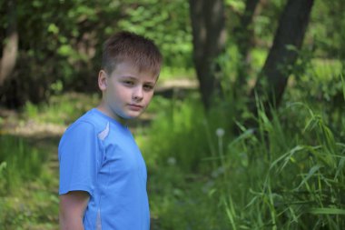 Bir gencin parkta yürürken bir fotoğrafçı için poz veriyor.