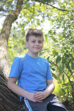 Bir gencin parkta yürürken bir fotoğrafçı için poz veriyor.