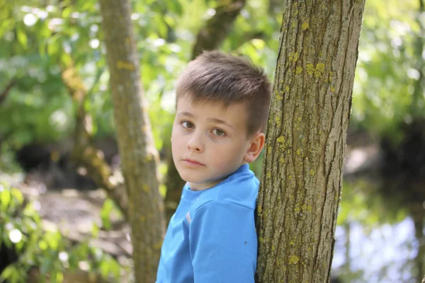 Bir gencin parkta yürürken bir fotoğrafçı için poz veriyor.